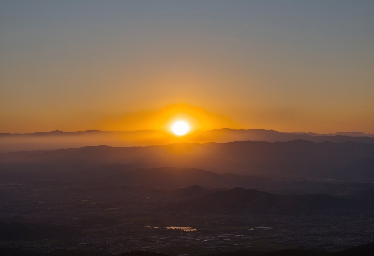 A sun setting over a sprawling California landscape, casting a golden glow over the mountains and valleys below